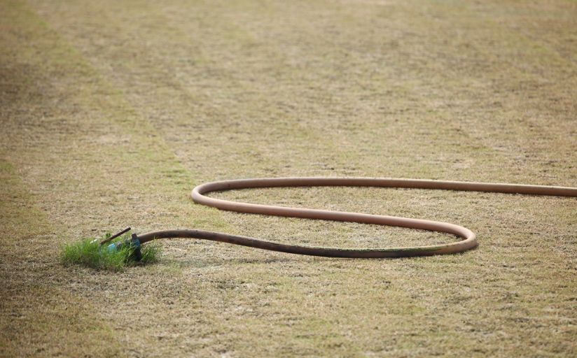 A water hose on a dormant lawn.
