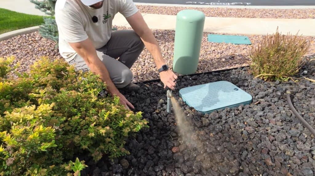 man blowing out sprinkler line with air compressor